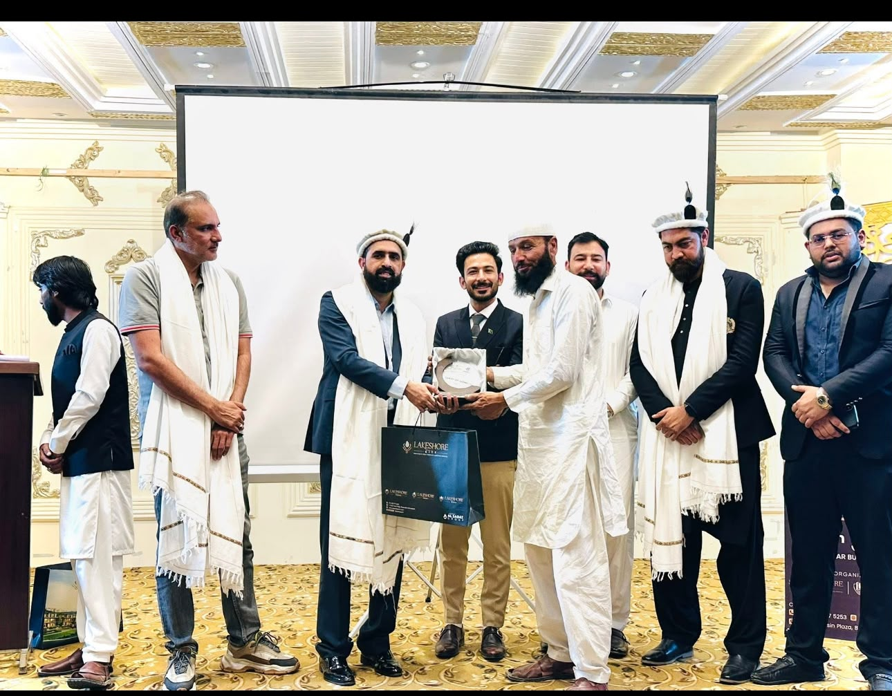 Zafar Abbas receiving an award alongside community leaders